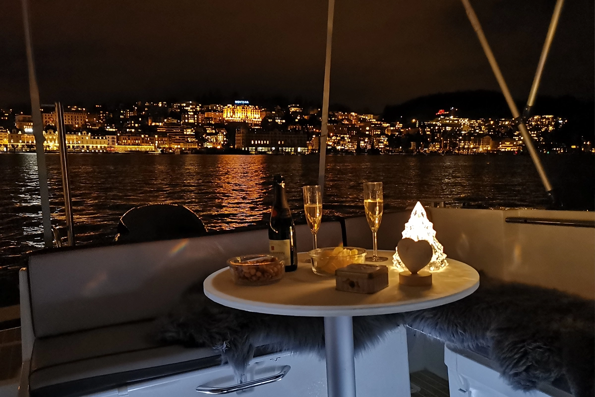 Boot mieten Luzern: gemütlicher Abend an Bord auf dem Vierwaldstättersee mit Stadtblick.